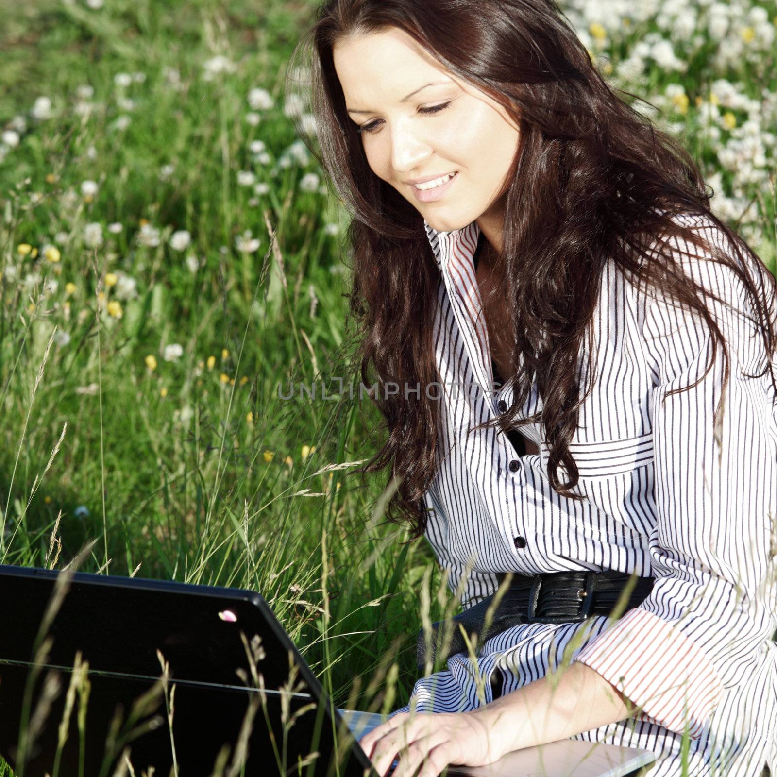 girl with laptop on green grass