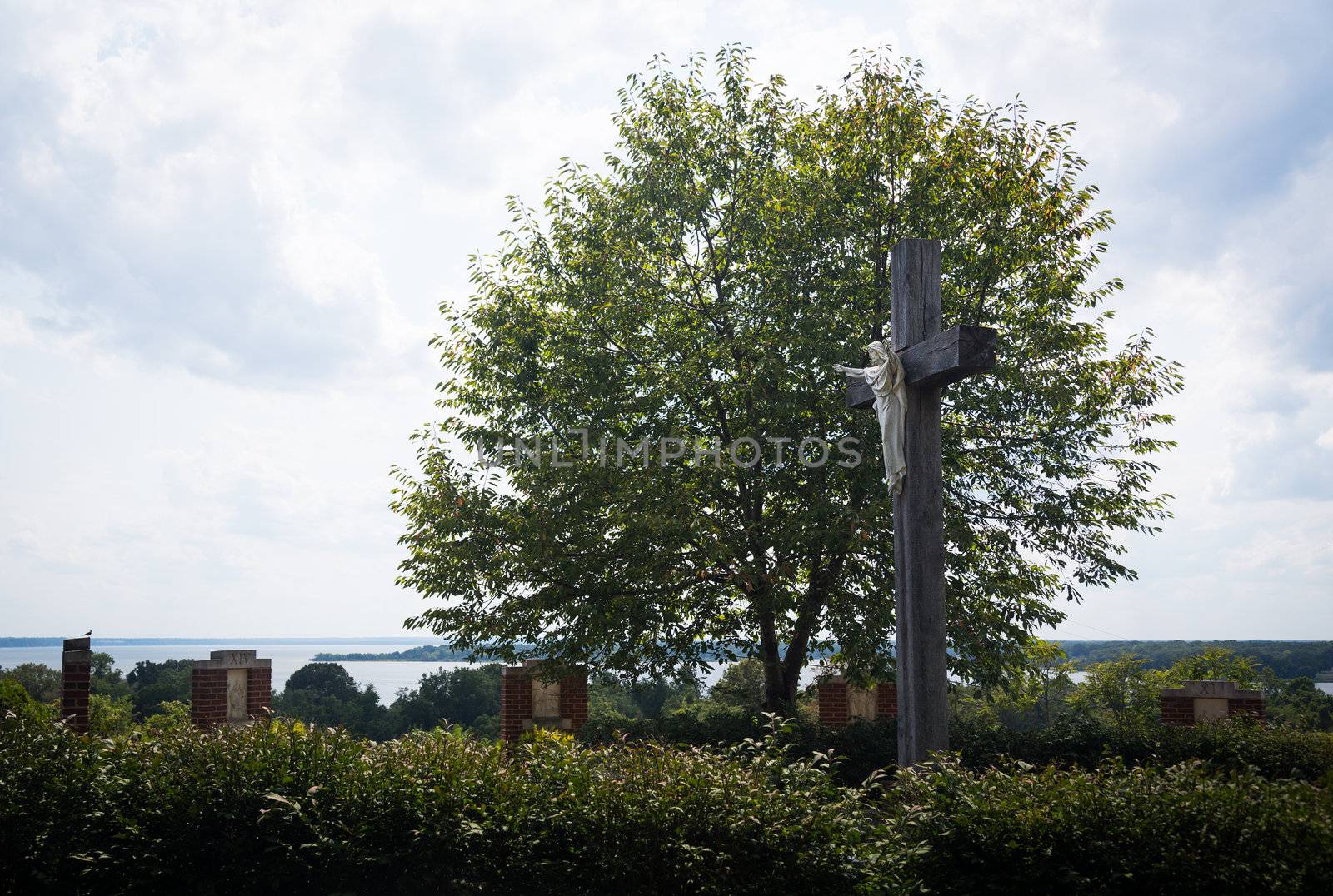 Statue of Christ being crucified on cross in stations of the cross overlooking estuary