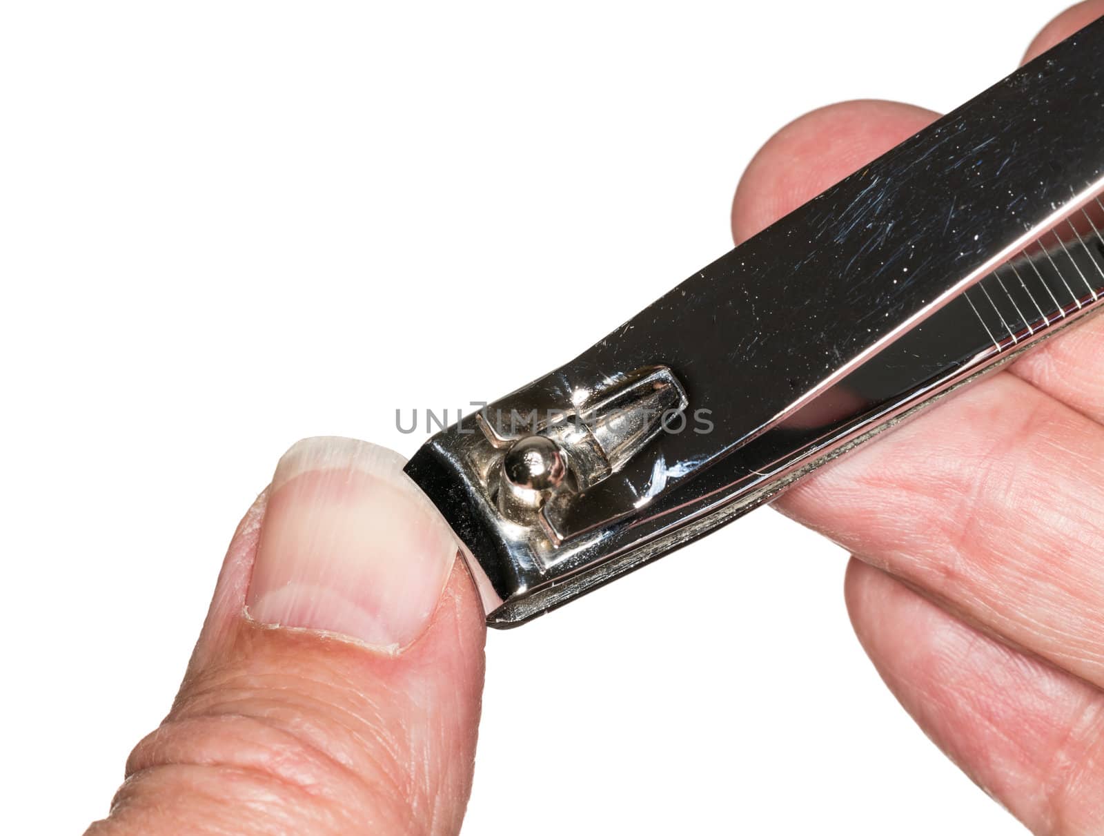 Macro photo of a set of nail clippers cutting thumbnail on senior caucasian thumb