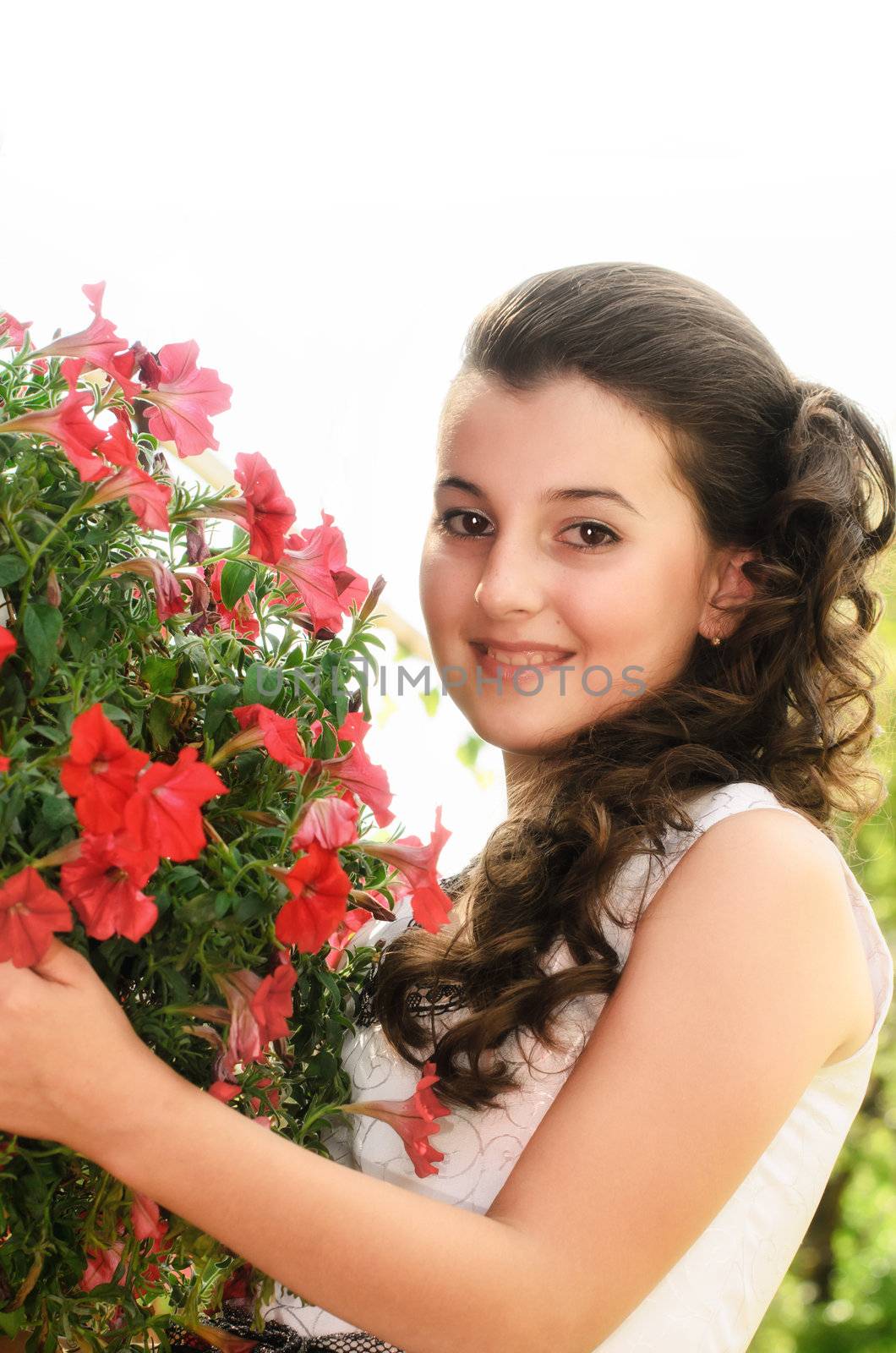 Little girl holding red flowers and looking at camera