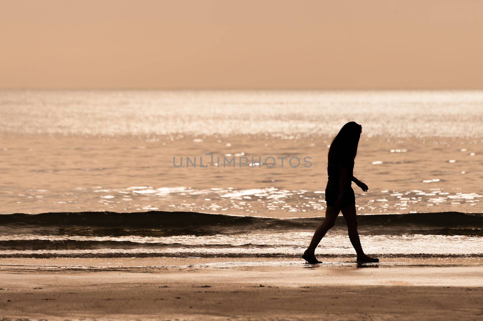 sillhouette woman walking on the beach