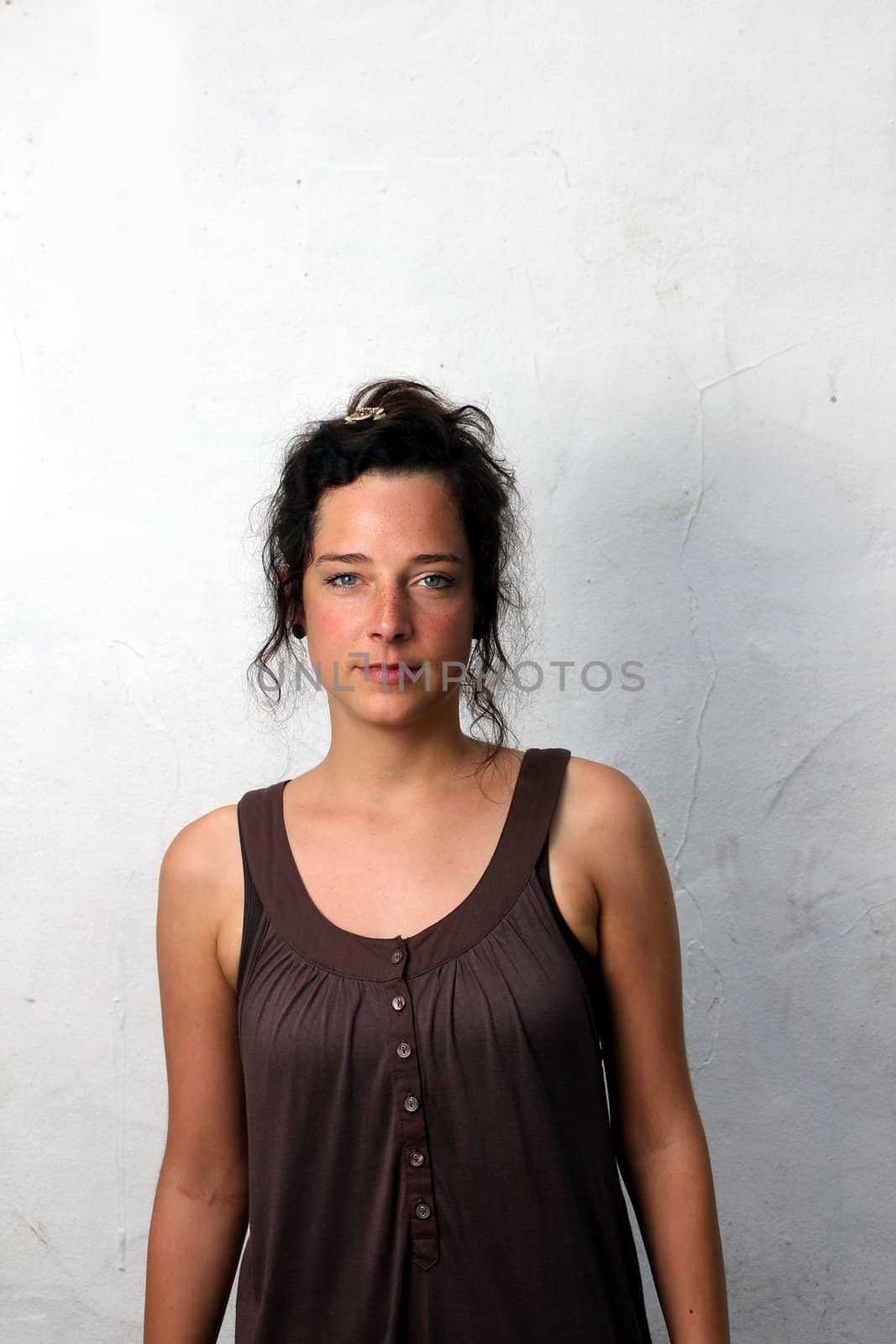 young woman in front of a plain wall