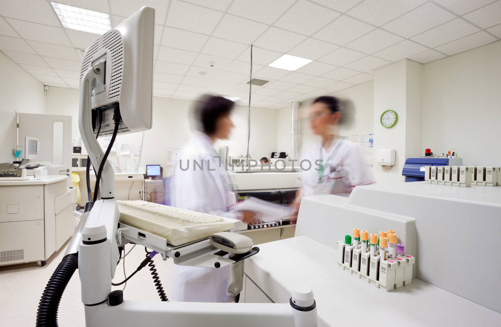 Blurred figures of two laborants with medical uniforms in modern clinical laboratory