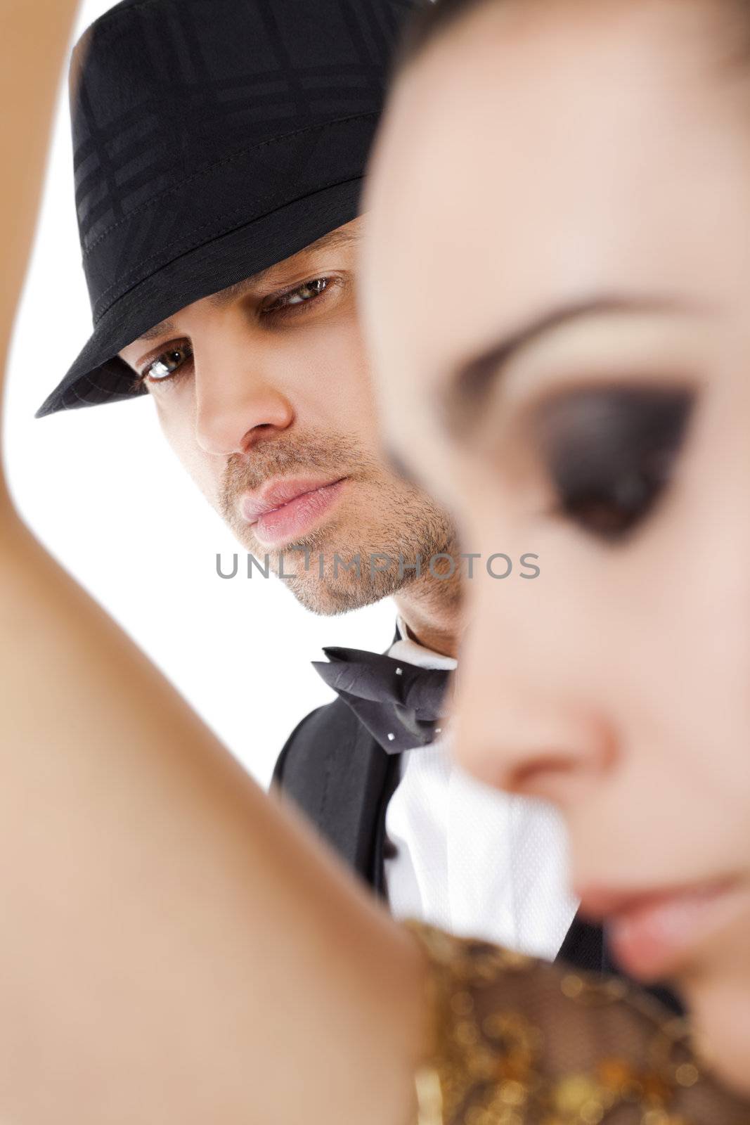 Young handsome man with hat looking at camera behind woman silhouette