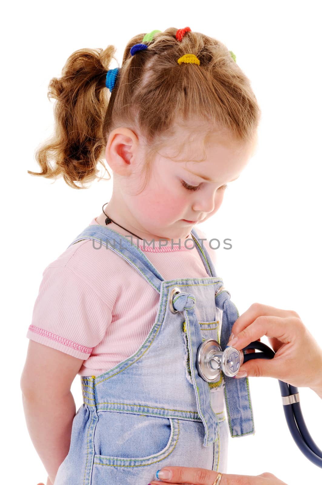 Healthy small girl is examed by stethoscope isolated on white background. The girl is looking down.