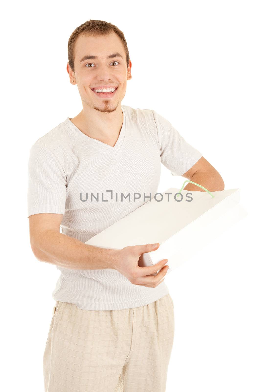 Glad handsome man is checking inside white gift paper bag. Isolated on white background.