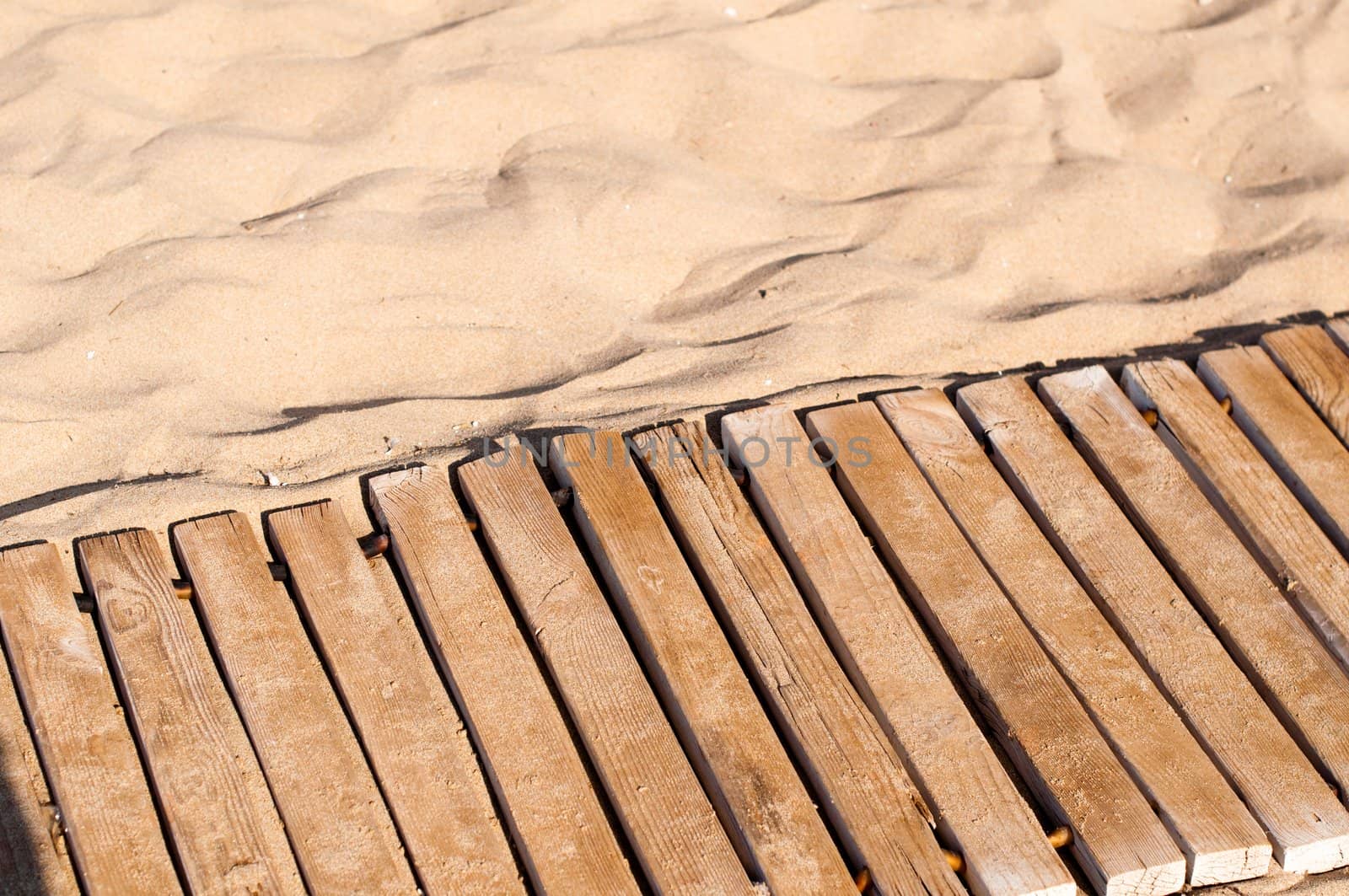 Weathered wooden boardwalk on sand on Crete Island in Greece