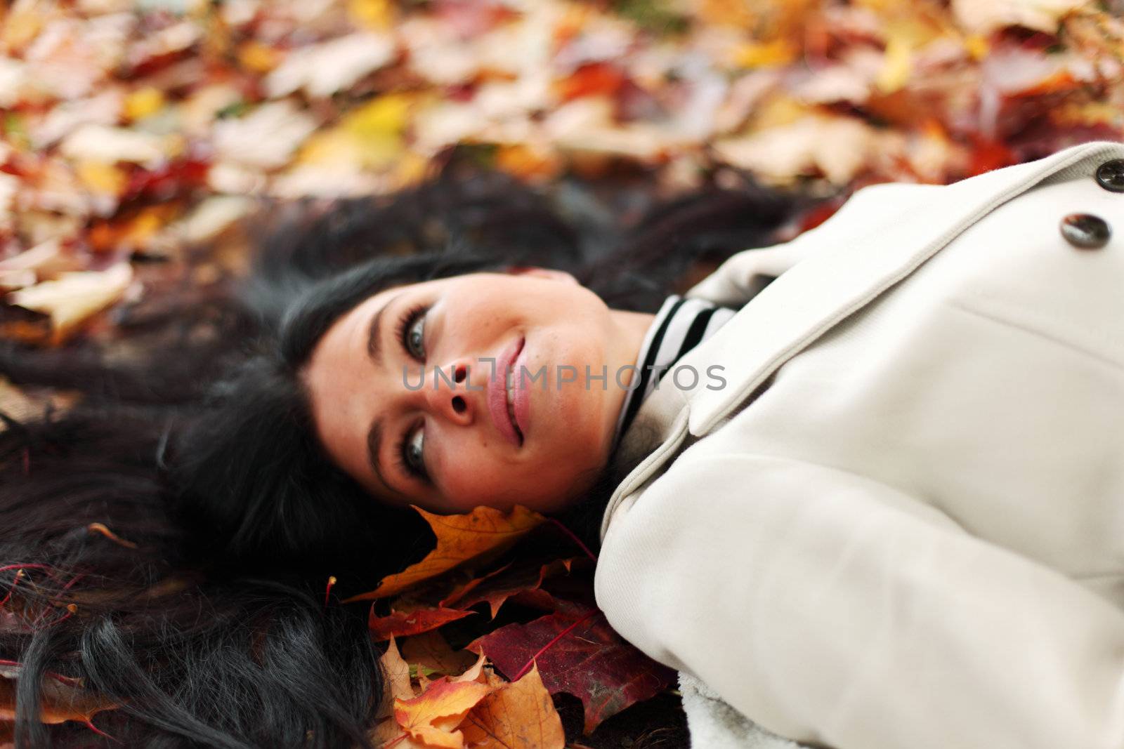 woman lay on yellow autumn leaves