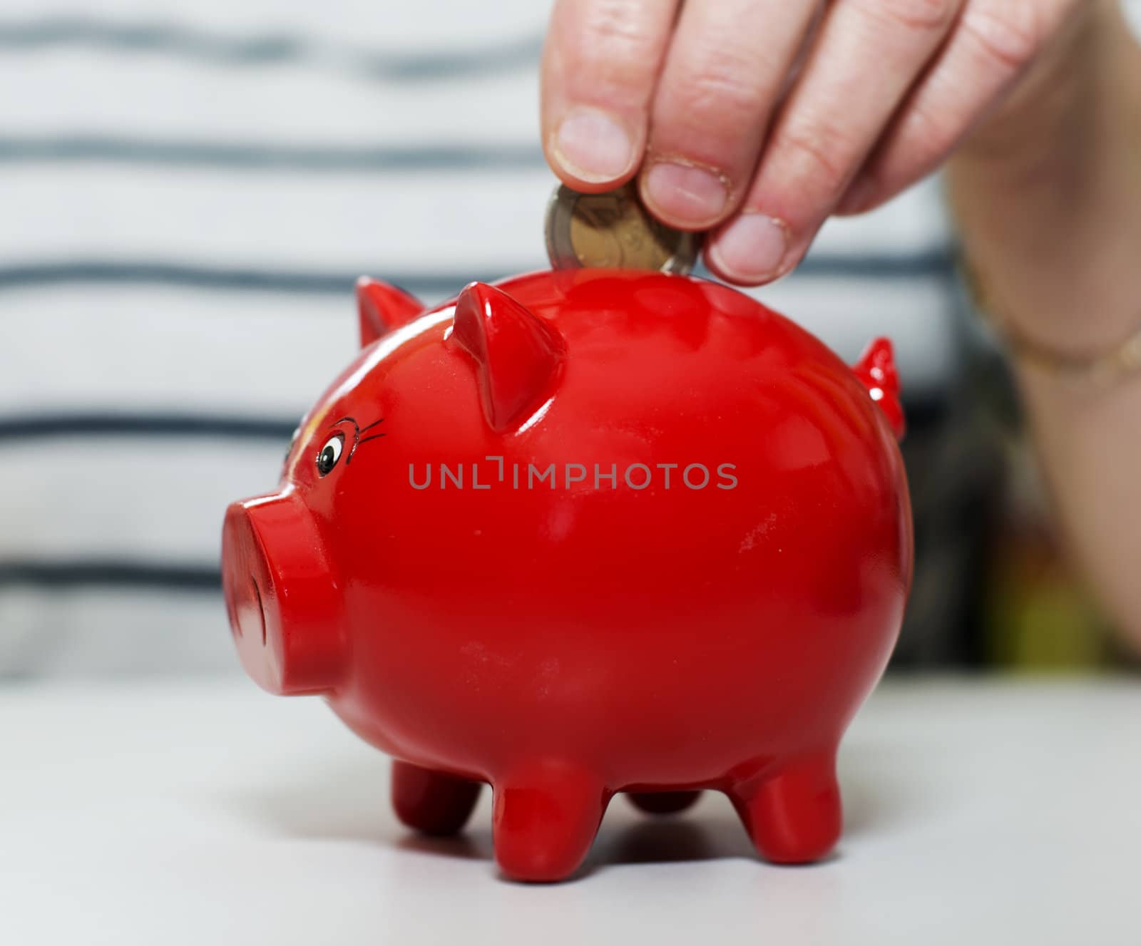 female hand putting euro in money pig