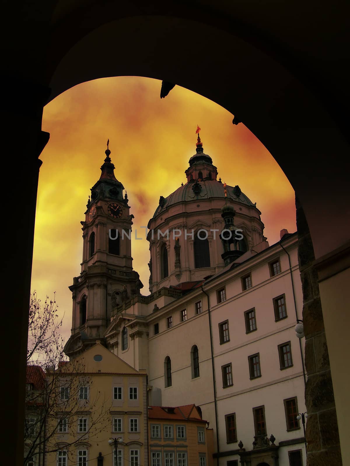           Church of Saint Nicholas in Prague at sunset framed in portal 