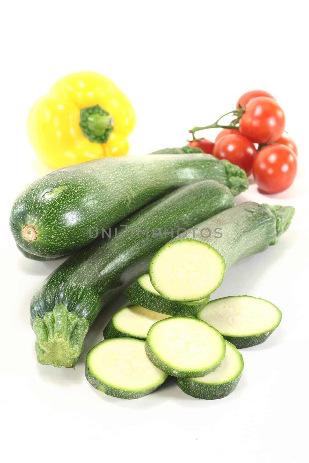 fresh zucchini with red tomatoes and bell pepper on a light background