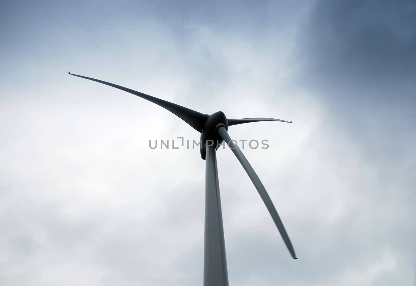 Wind turbine propeller and a gray cloudy sky
