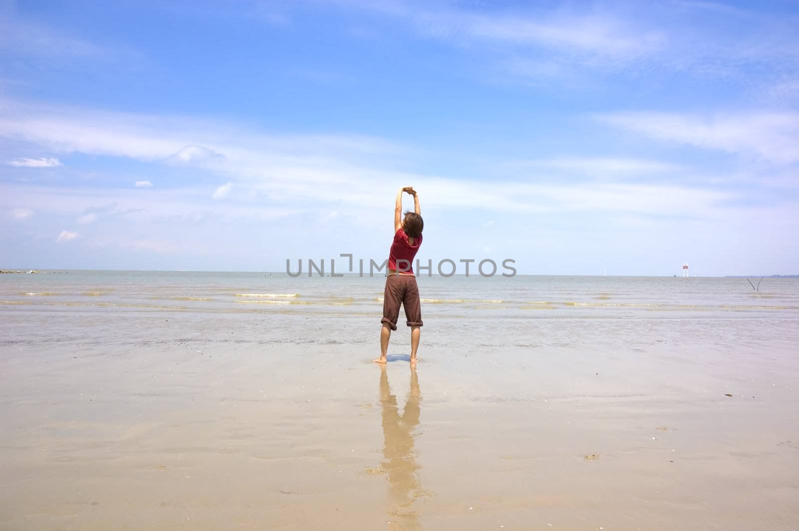 asian girl performing yoga on a beach