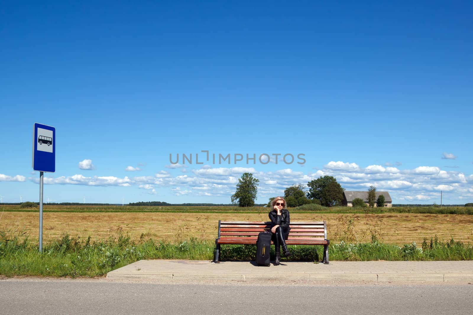 lonely bus stop at countryside with women on bench