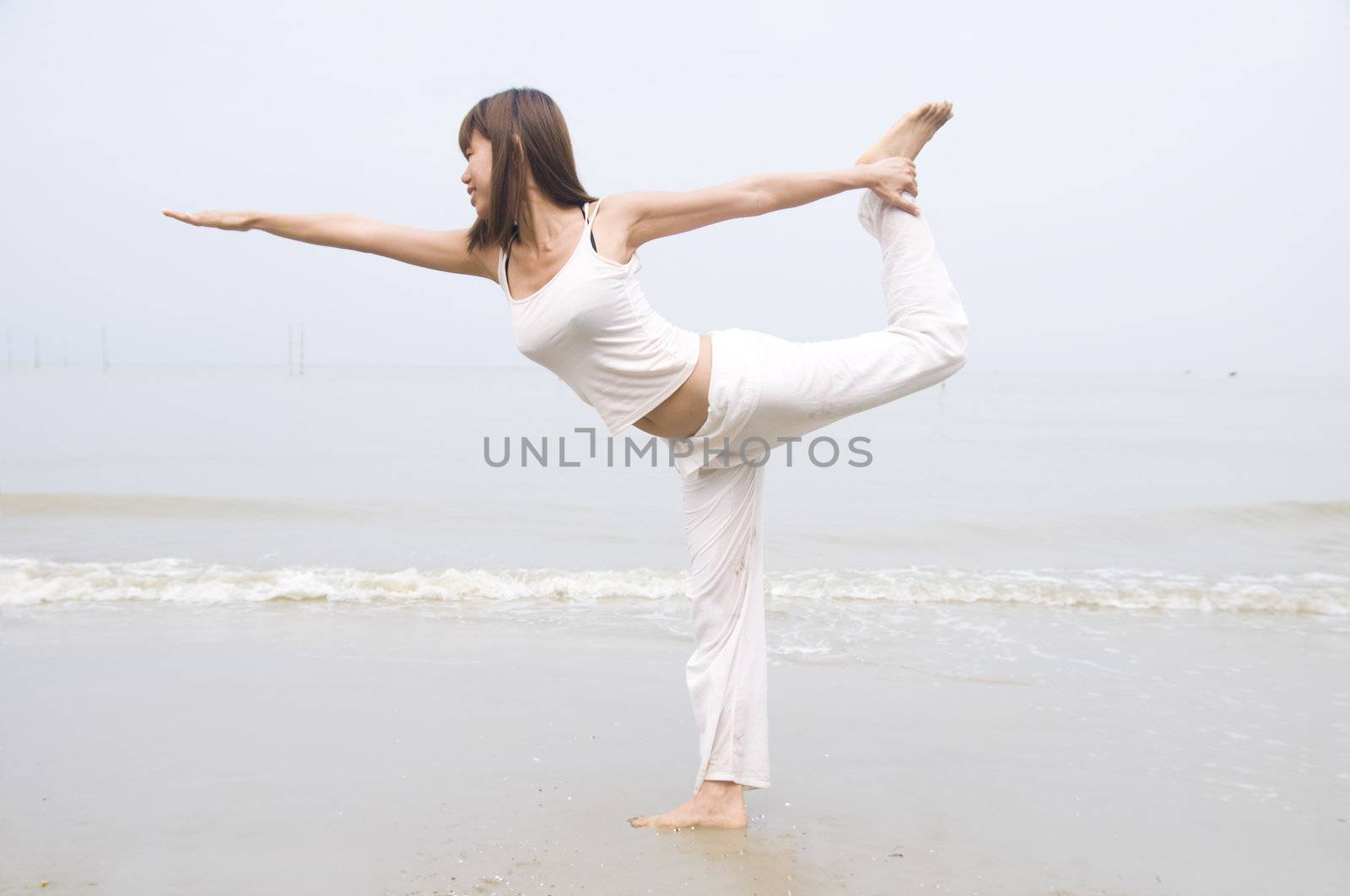 asian girl performing yoga on a beach by yuliang11