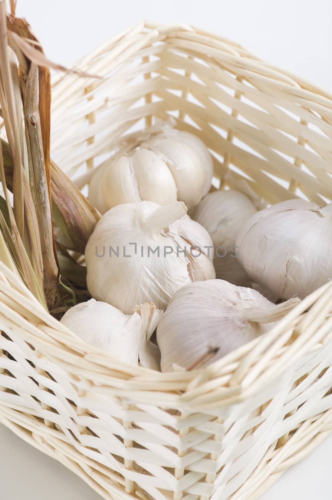 garlic with dried lemon grass inside a rattan basket by yuliang11