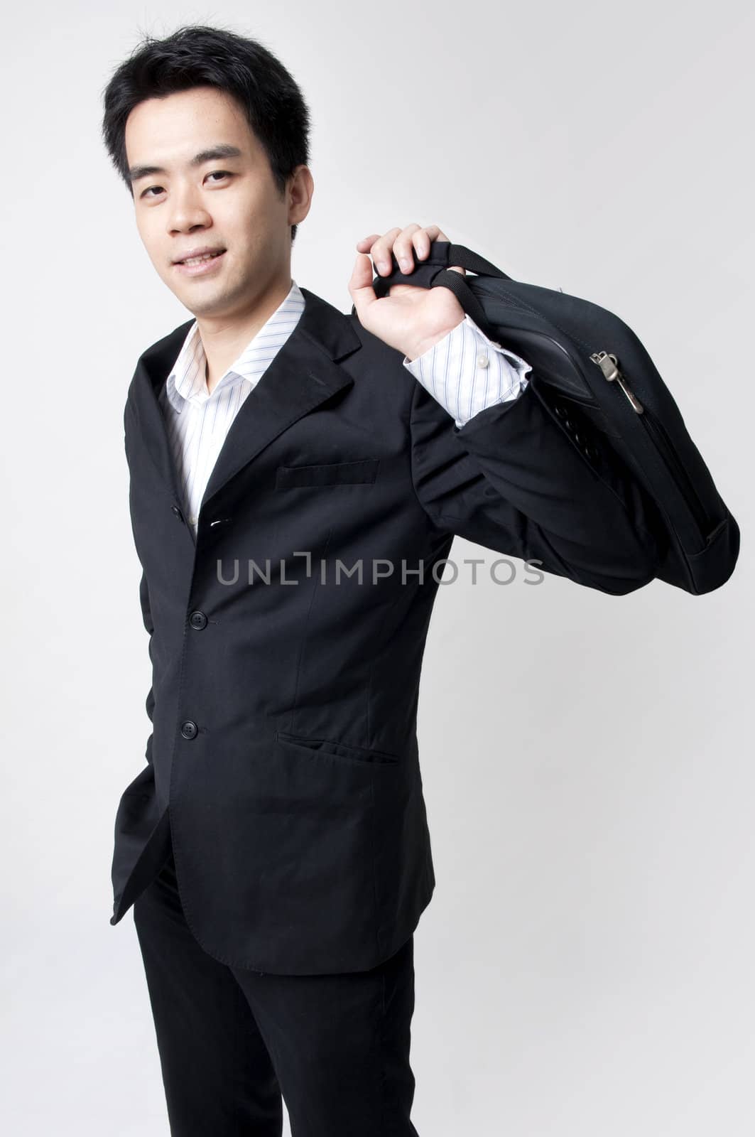 young male executive holding a business bag and smiling