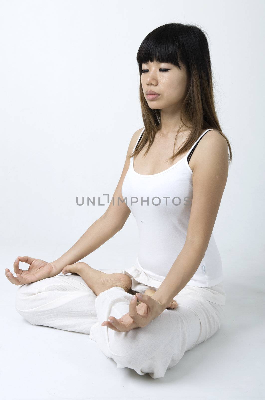 portrait of an asian girl performing yoga in a studio 