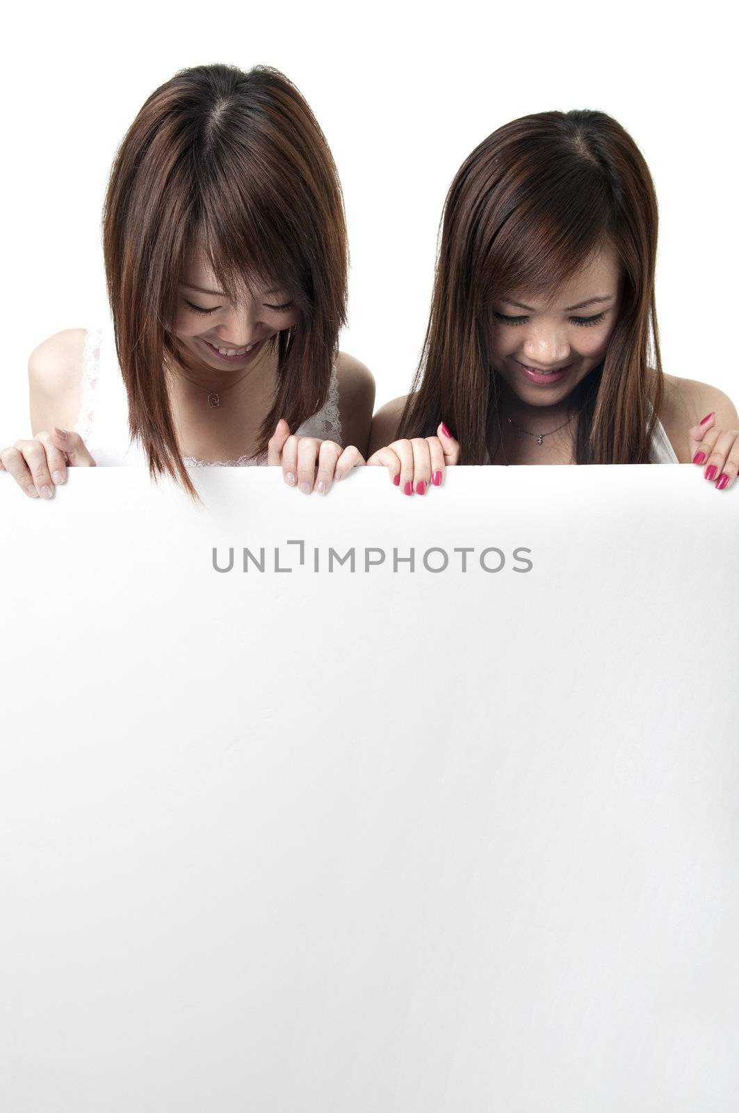 two young asian girls holding a blank cardboard