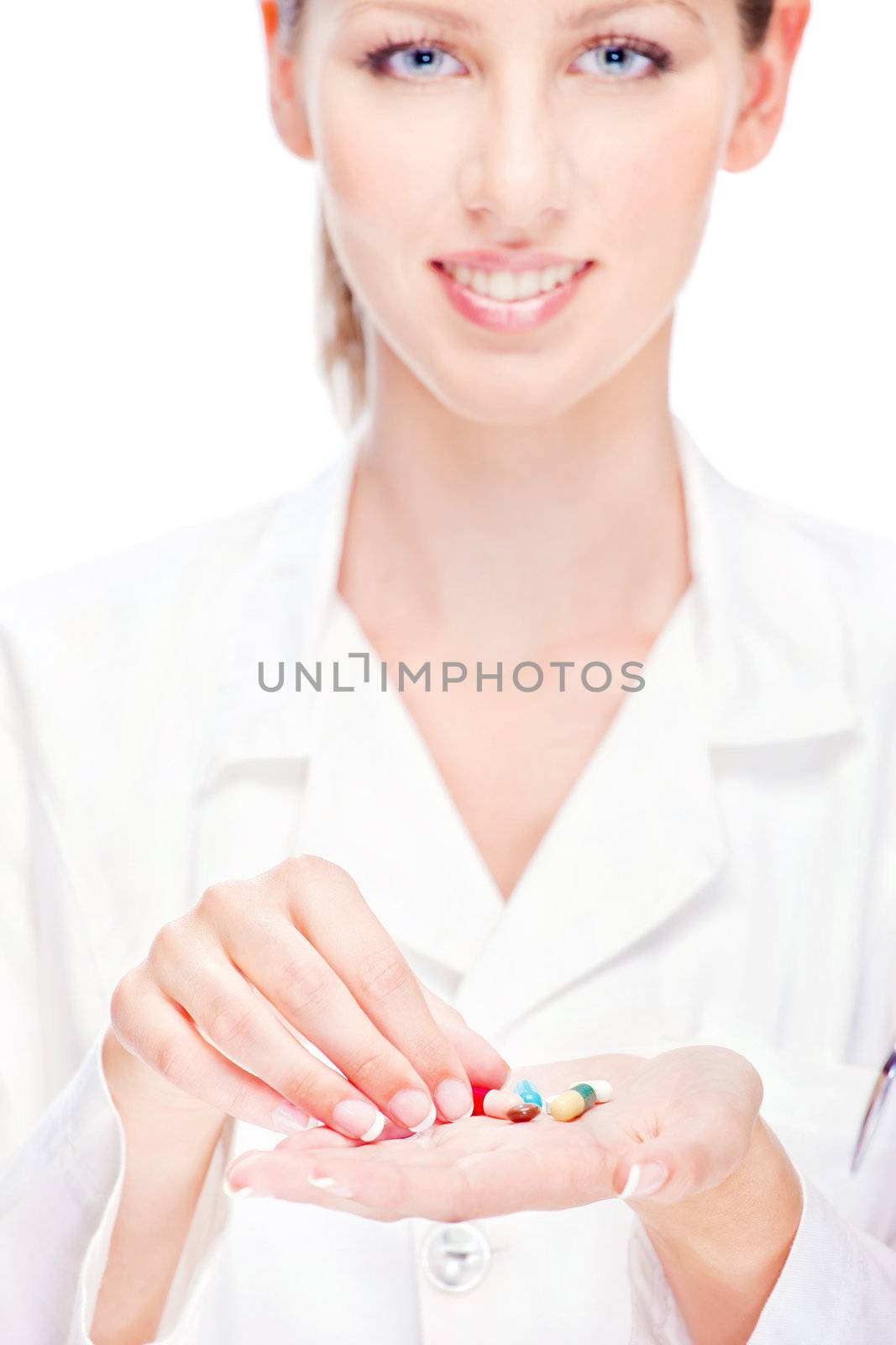Pretty female nurse holding  pills, focus on pills