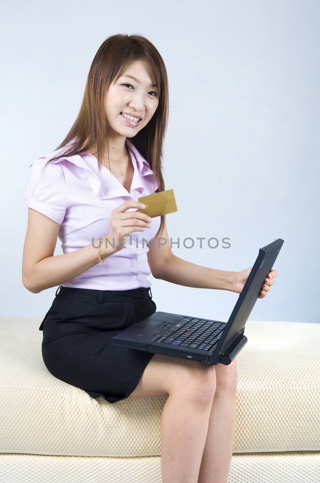 asian business women online shopping with a blank credit card 