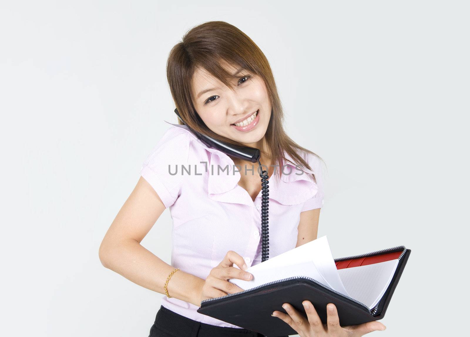 asian business women smiling with a notepad and phone