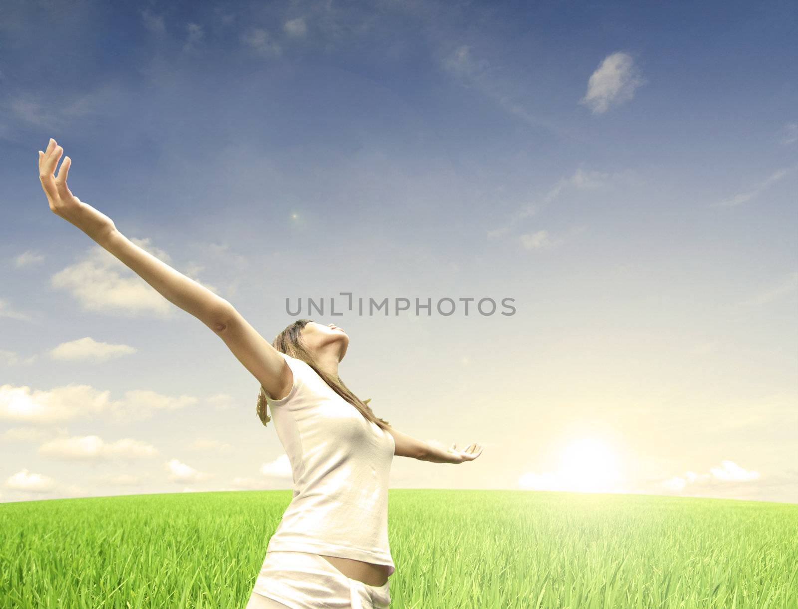 asian girl relaxing on a green field during early morning sunrise 
