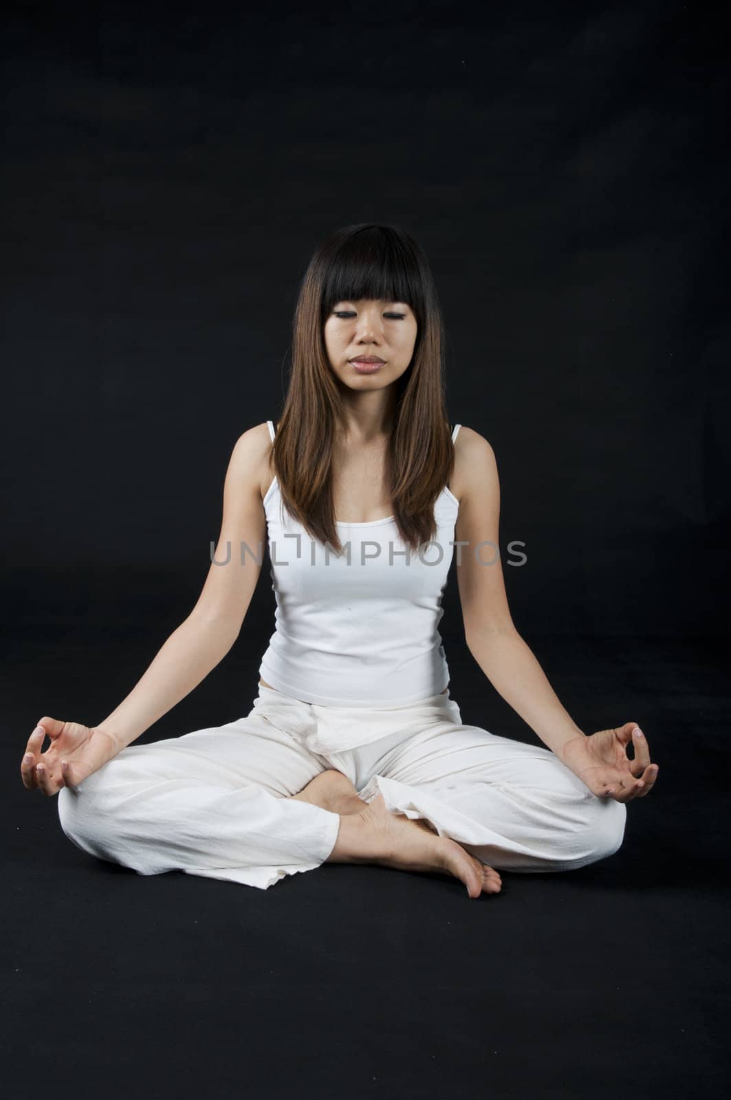 asian girl performing yoga with dark background 