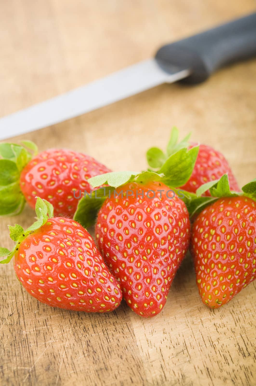 strawberries with kitchen knife on background,looks good for ingredients 