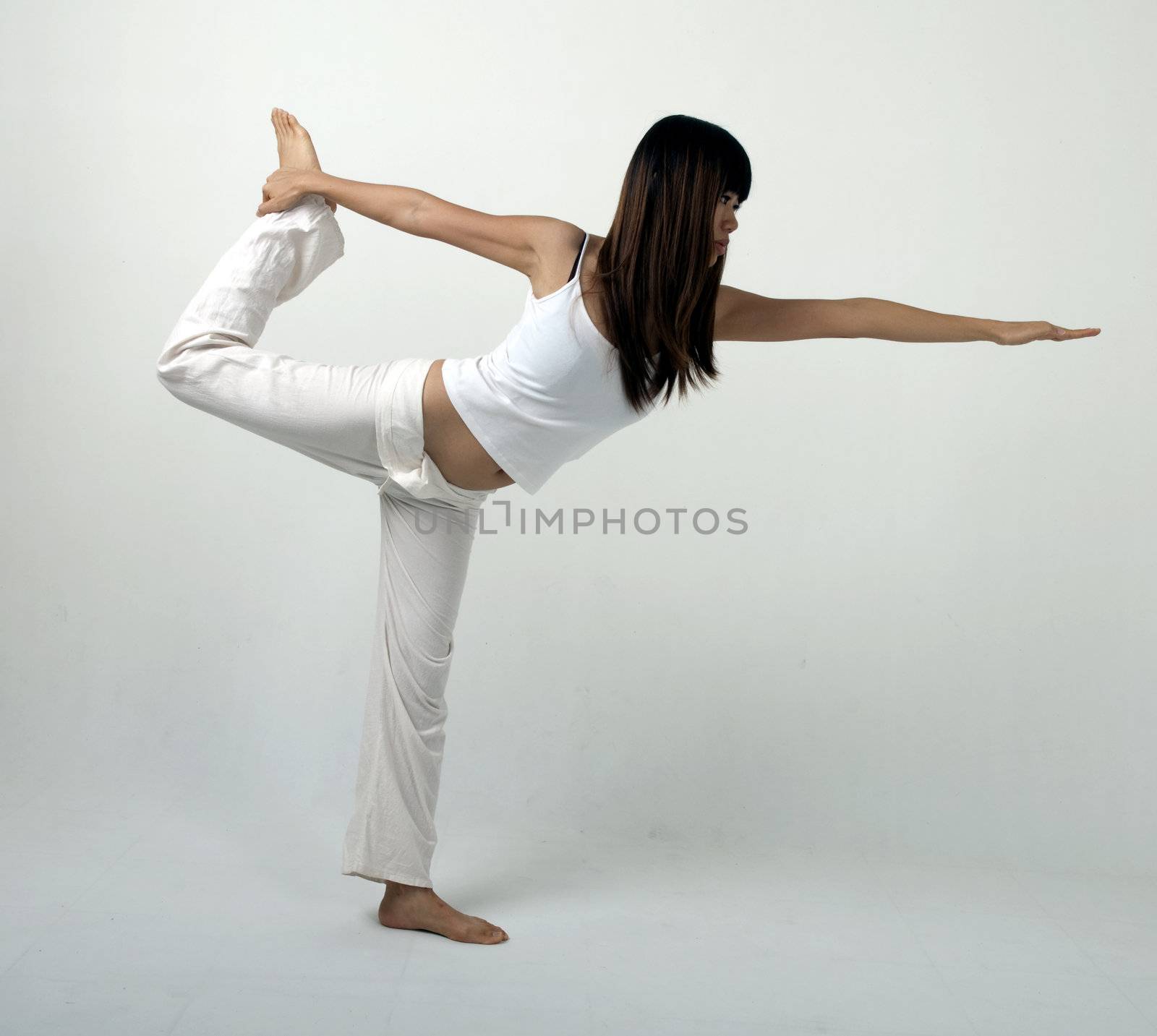 asian girl performing yoga  stand position with light background