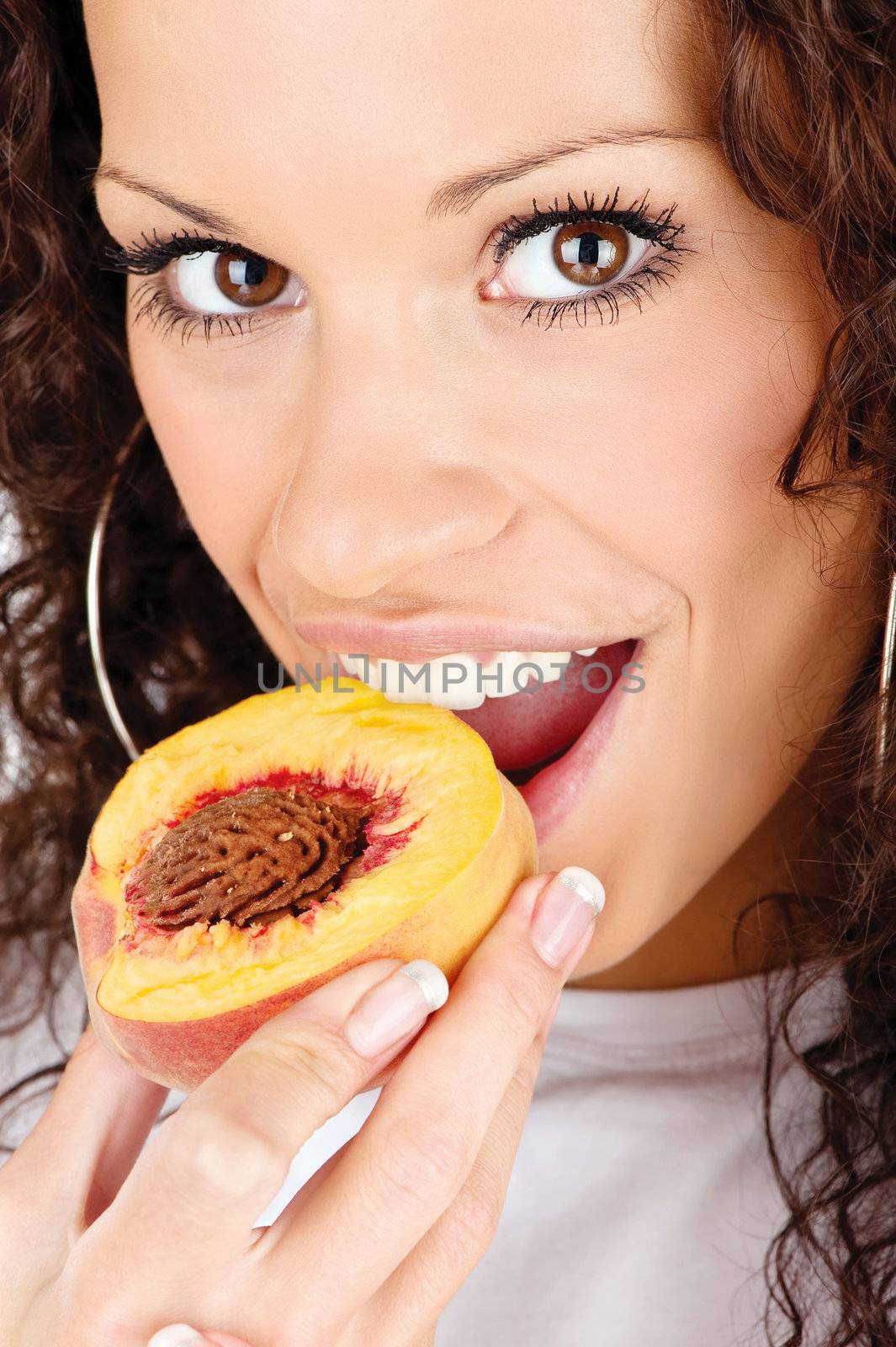 Close up of a pretty woman eating slice of peach