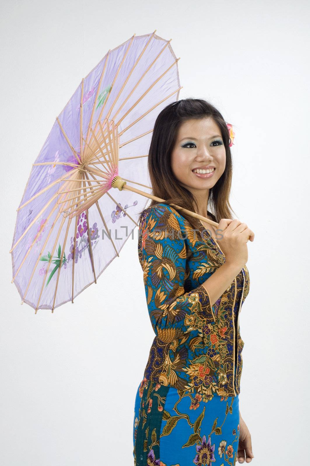 asian girl in kebaya dress with hand holding umbrella
