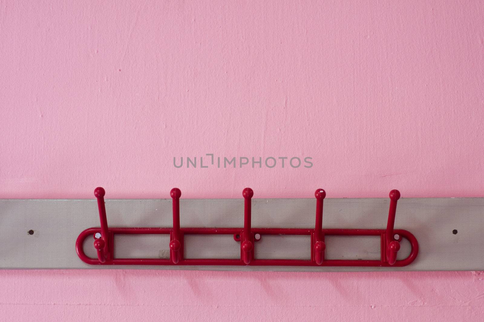 red coloured cloth hanger on a pink wall