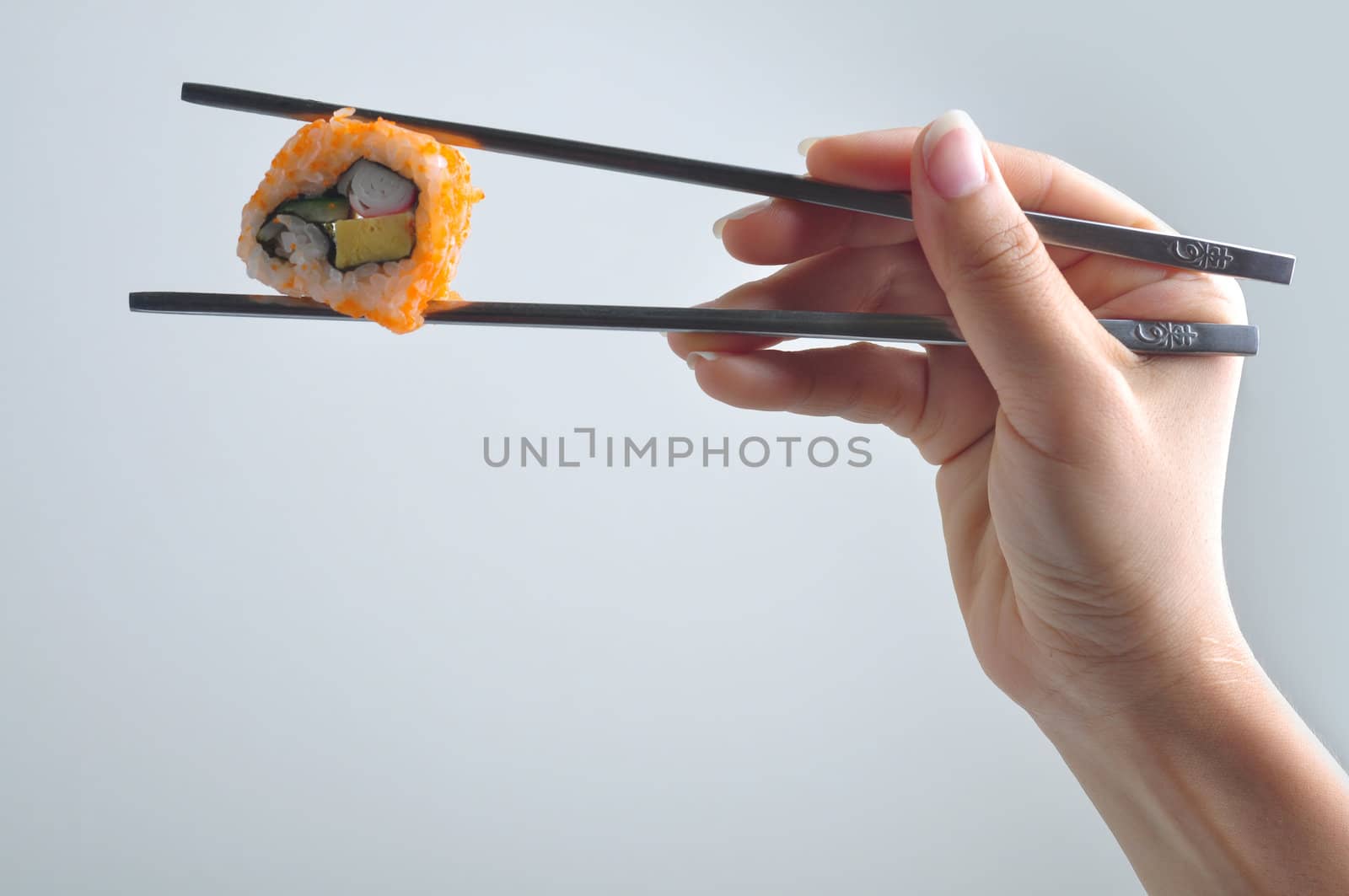 hand with chopstick holding sushi