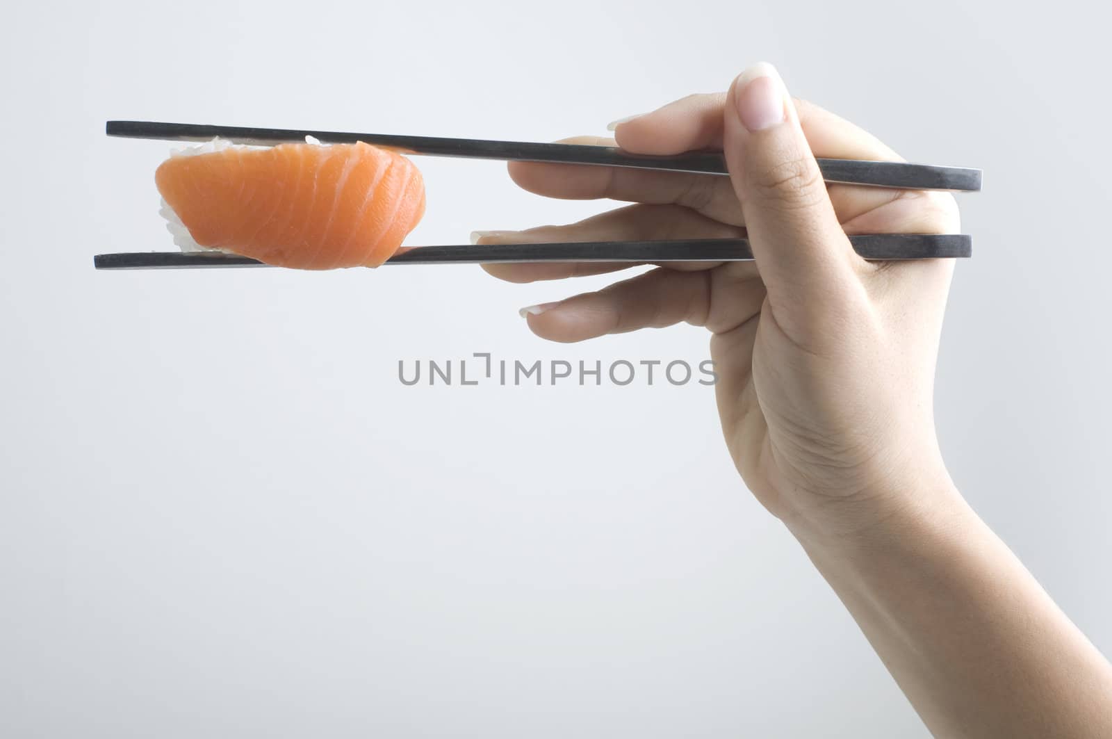 hand with chopstick holding a sushi food
