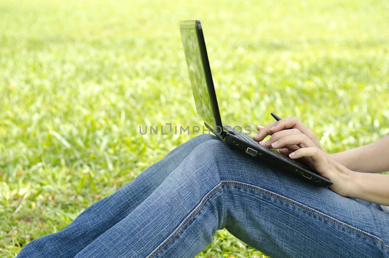 asian girl using laptop with green grass outdoor