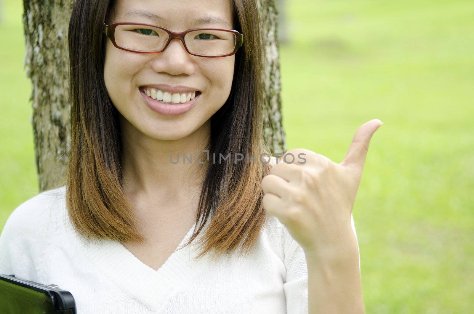 happy asian girl giving a thumbs up 