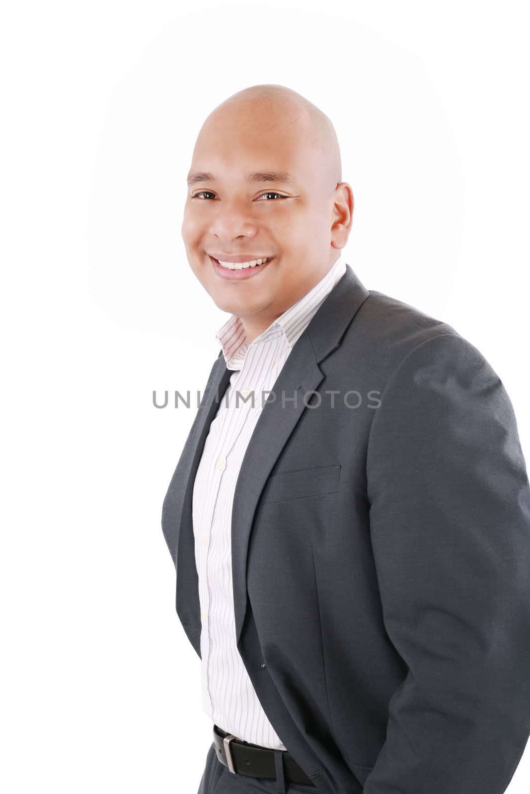 Happy businessman standing with hands in pocket, looking at camera, smiling. Isolated on white background