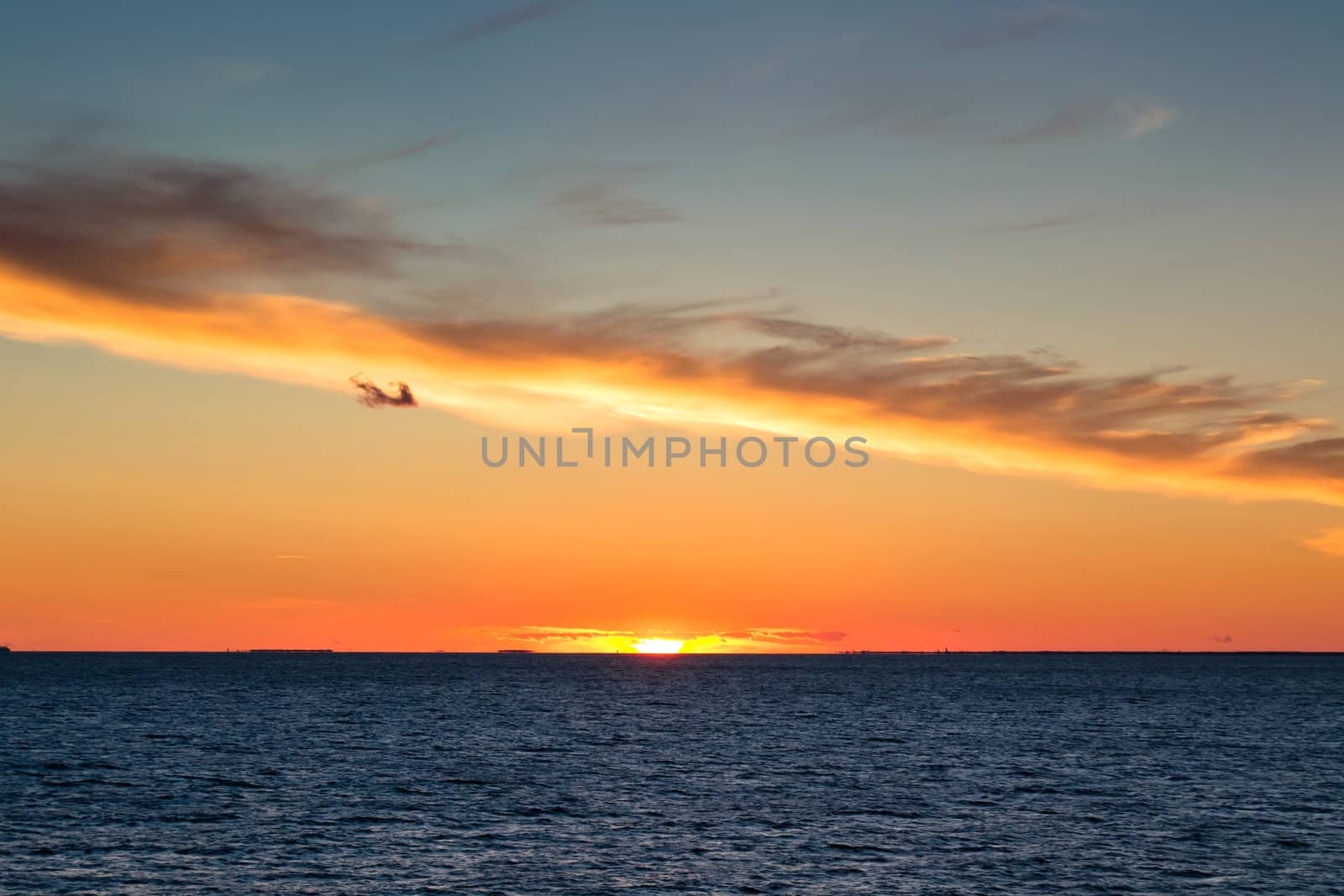 Beautiful sunset with cloud like a line and rippled sea