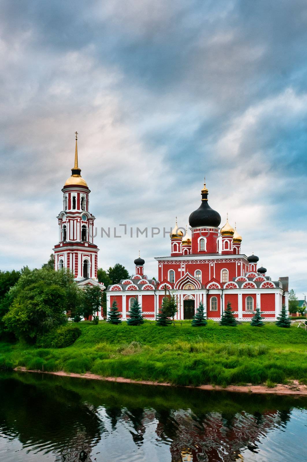Red church on coast of the lake in Russian village