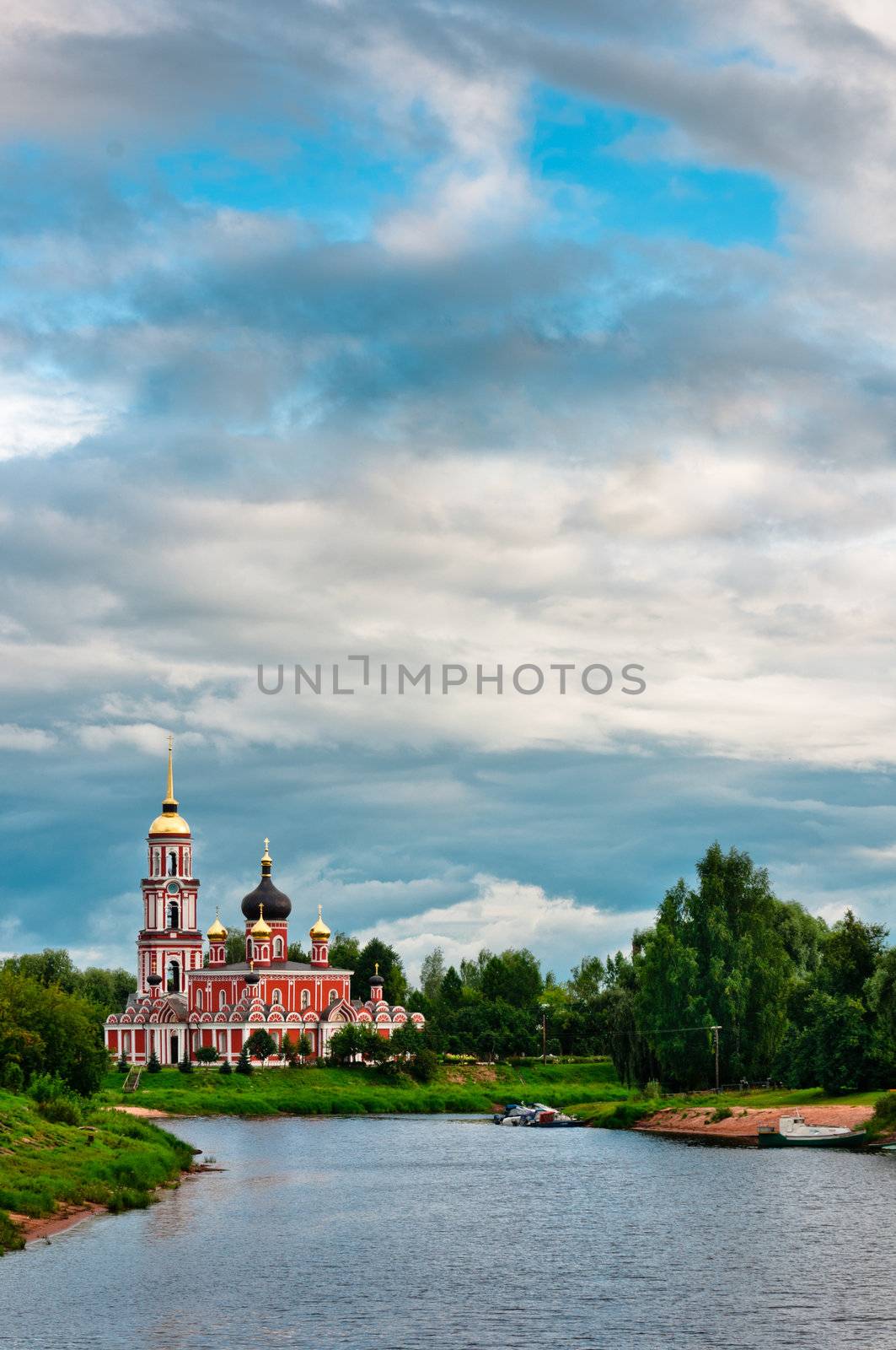 Red church with beautiful cloudscape on coast of the lake