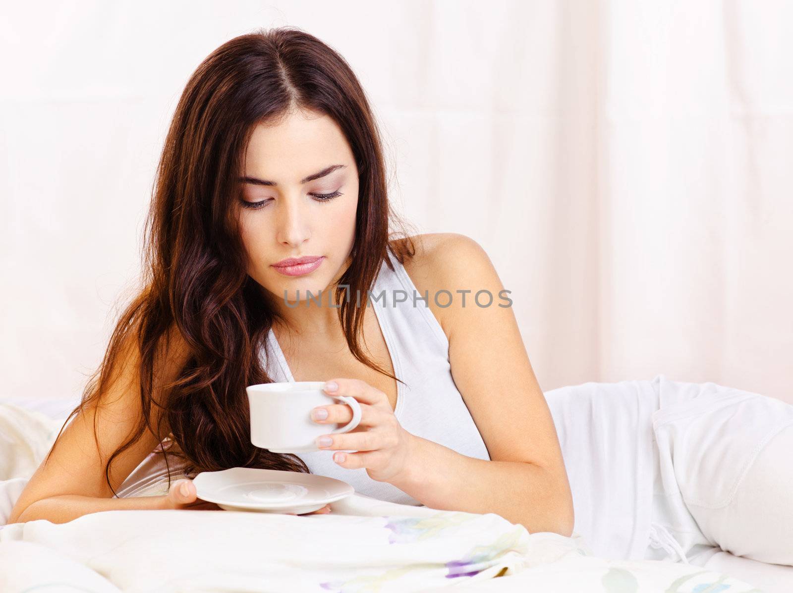 woman dink coffee in bed by imarin