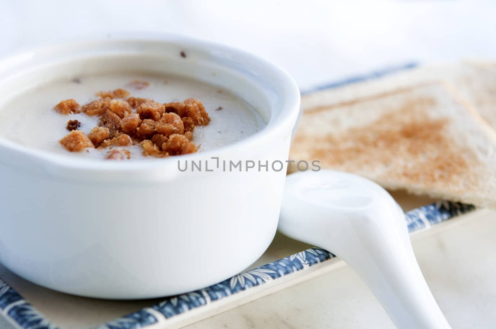 creamy mushroom soup on a table with spoon and bread