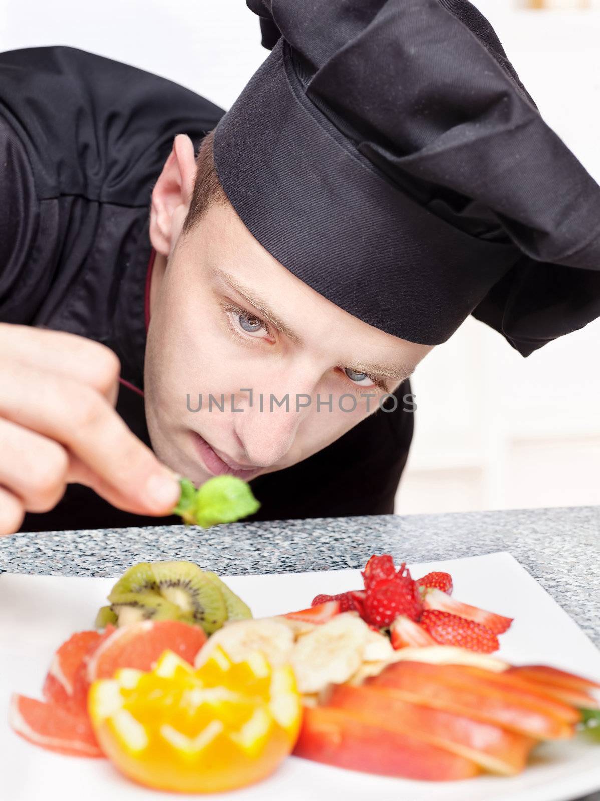 chef decorating delicious fruit plate by imarin