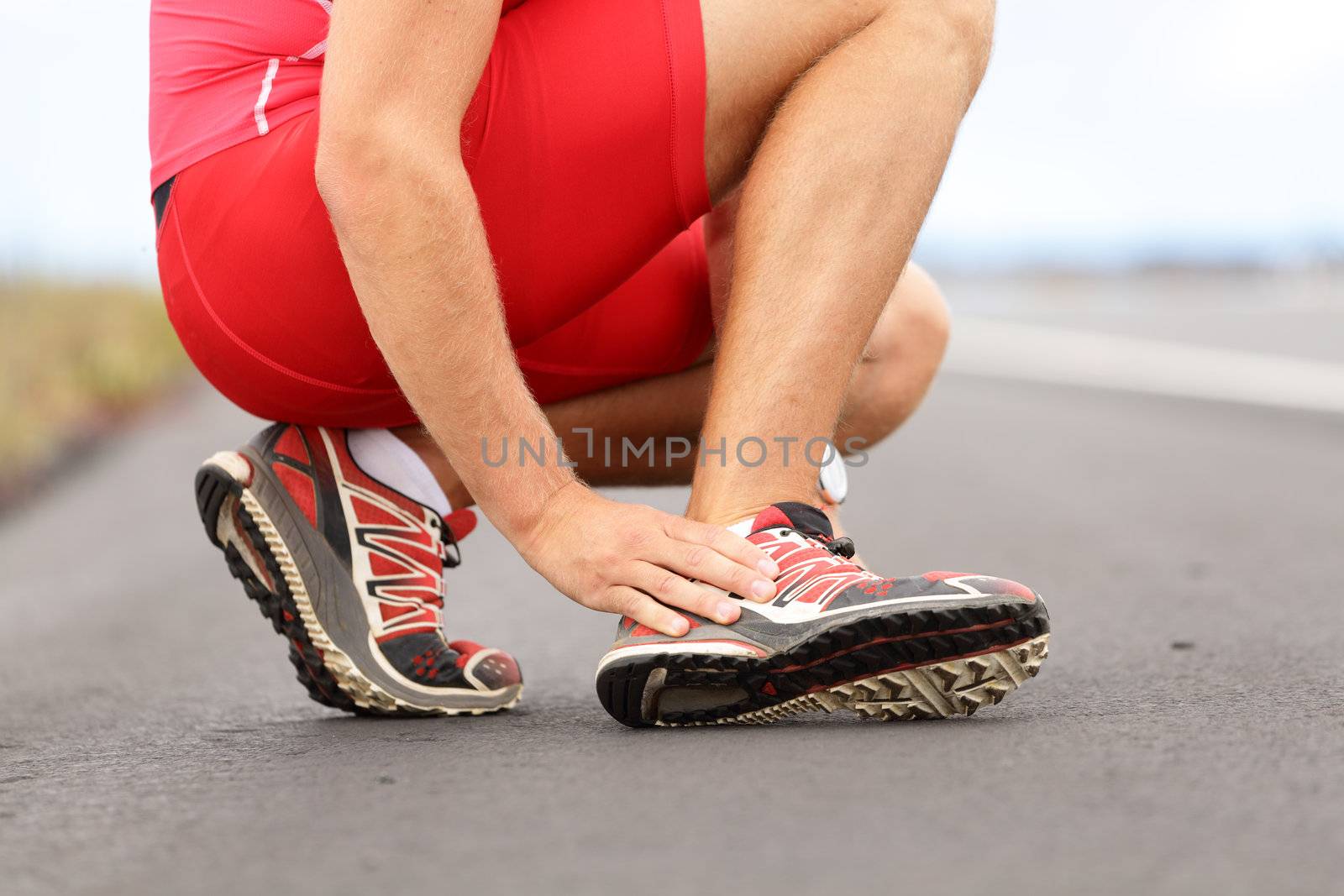 Broken twisted angle - running sport injury. Male runner touching foot in pain due to sprained ankle.