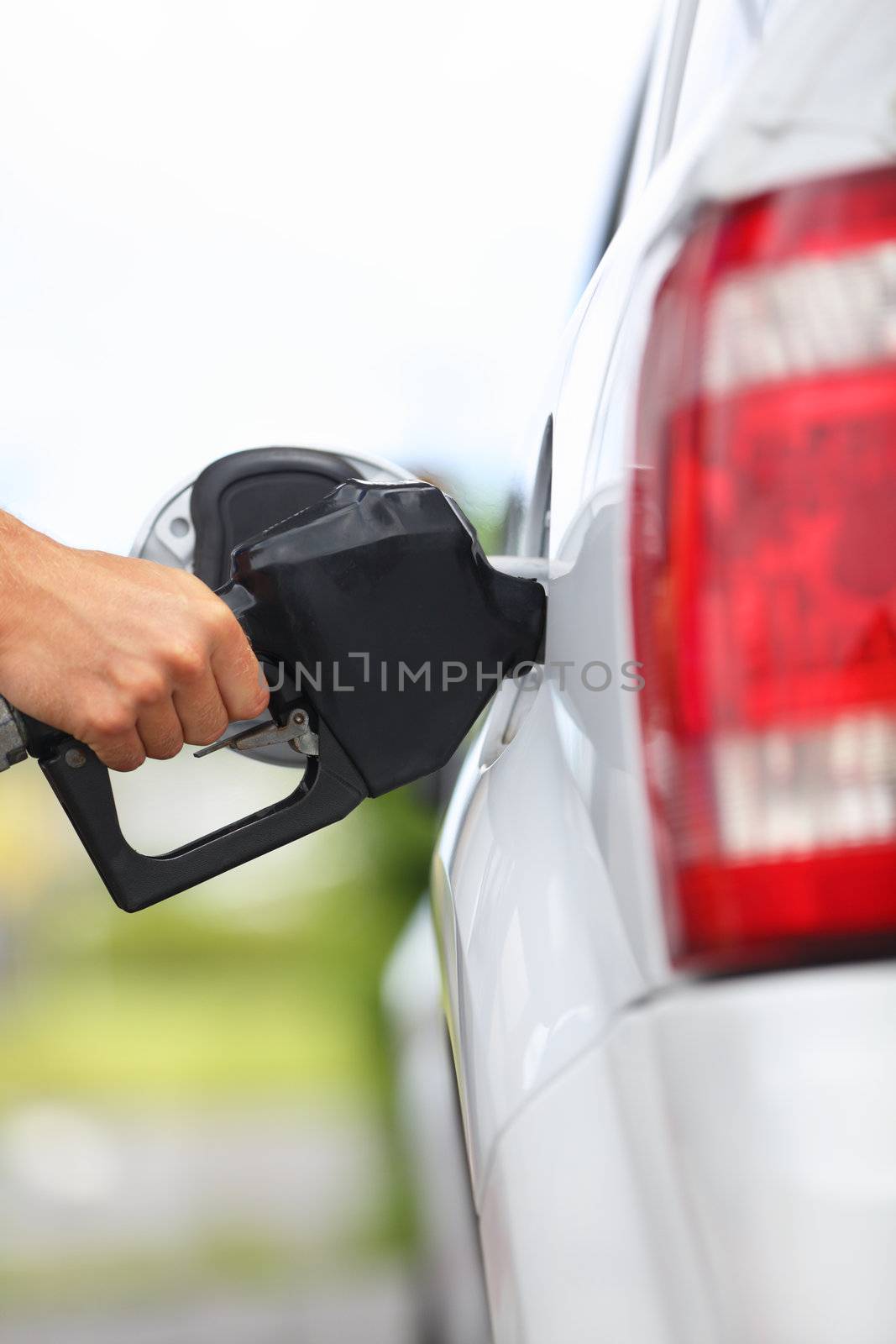 Gas station pump. Man filling gasoline fuel in car holding nozzle. Close up.