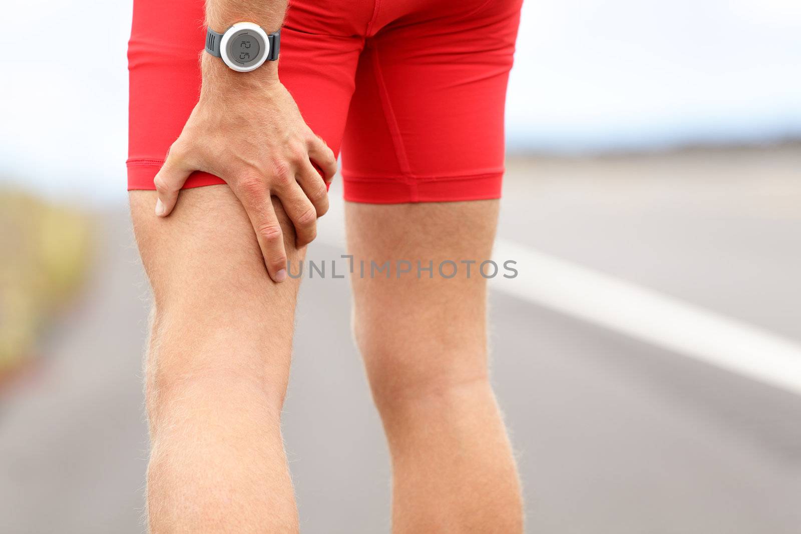 Hamstring sprain or cramps. Running sports injury with male triathlete runner.