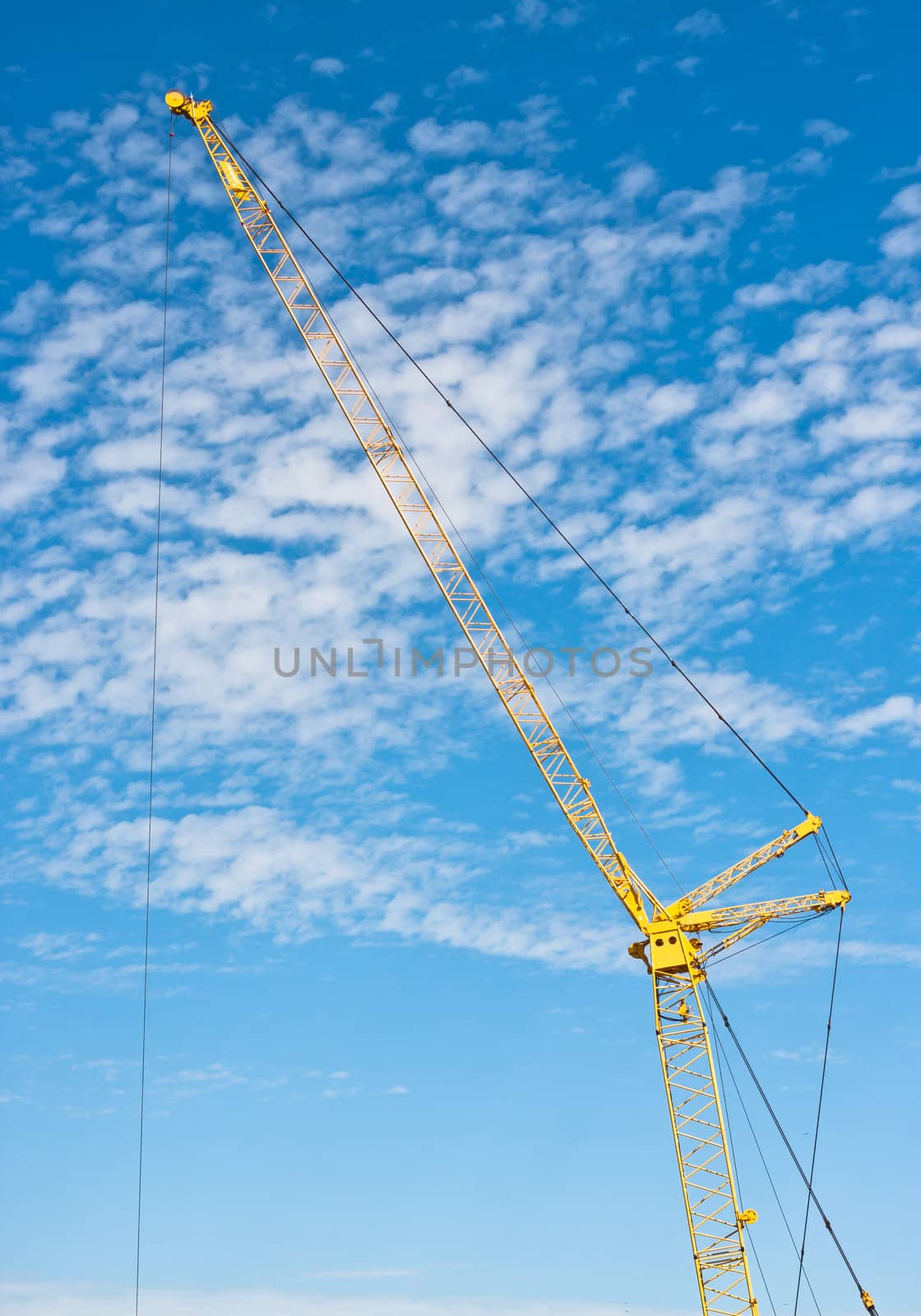 A yellow crane against a bright blue sky