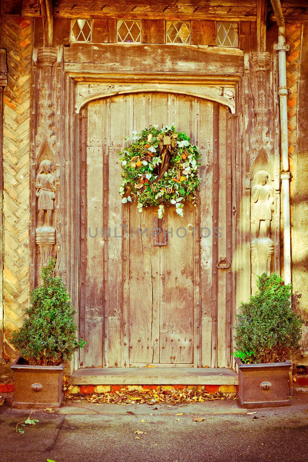 A decorative traditional christmas wreath on an old door