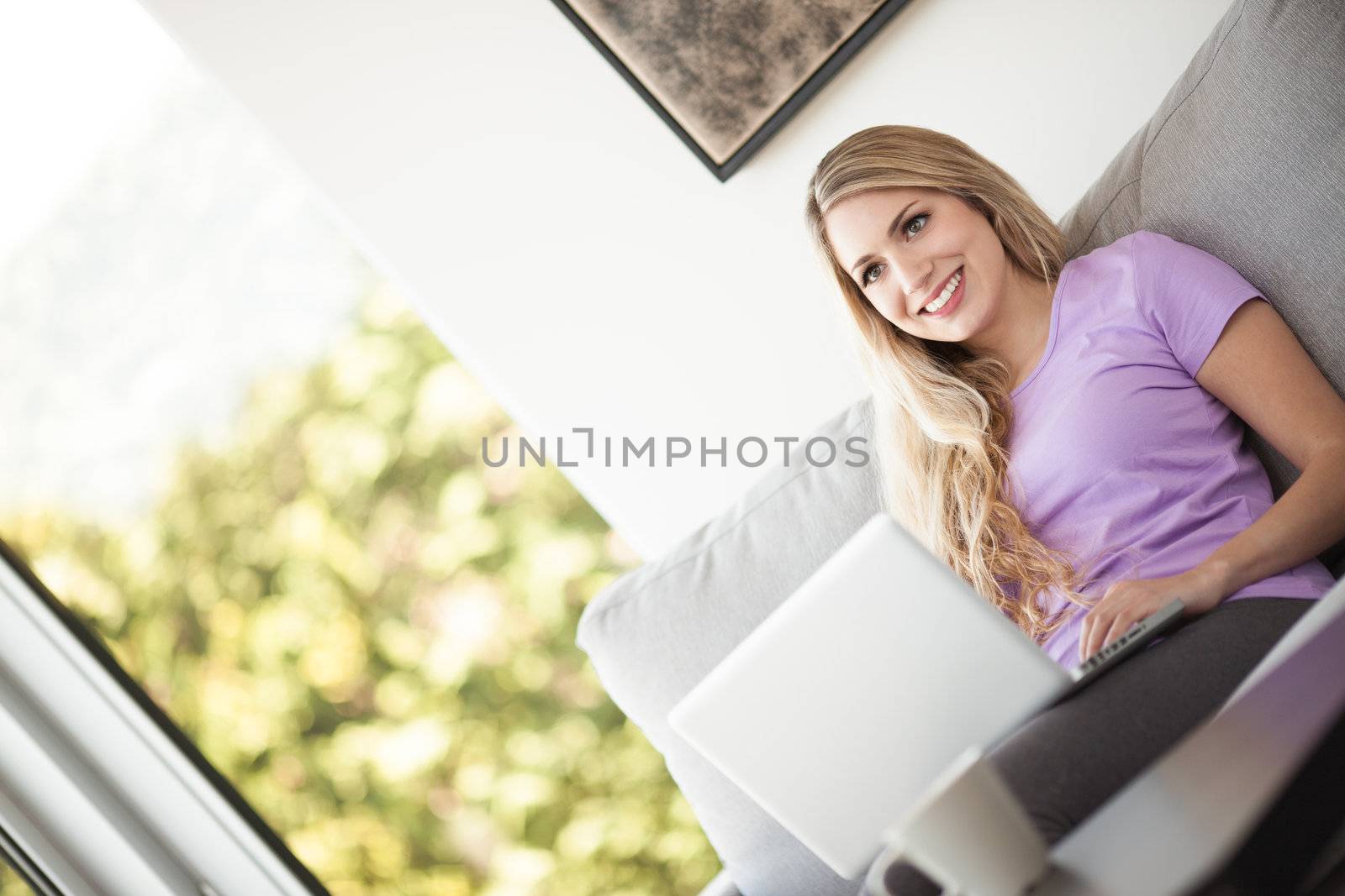young beautiful woman using a laptop at home by Lcrespi